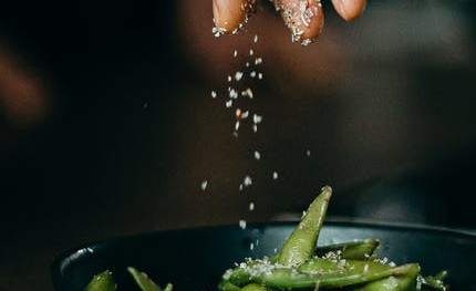 sprinkling salt on beans